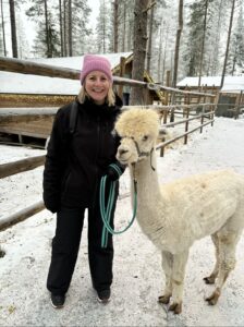 Image of Liz, The Good Space founder, walking a white Llama in lapland